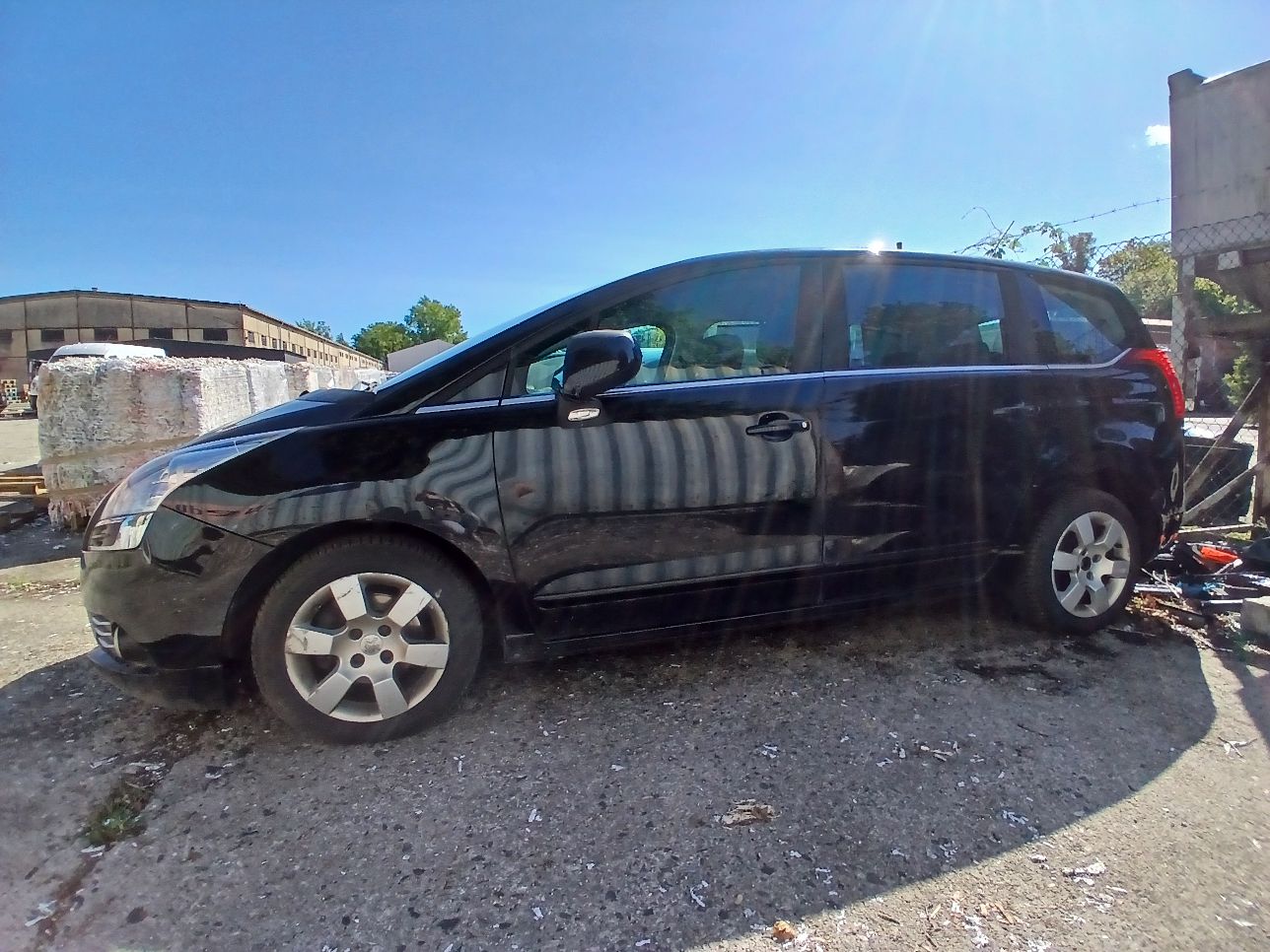 Lewy bok czarnego Peugeota 5008 bez widocznych uszkodzeń