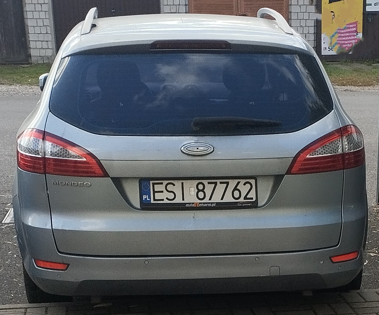 Srebrny samochód marki Ford Mondeo w wersji kombi, widok od tyłu.