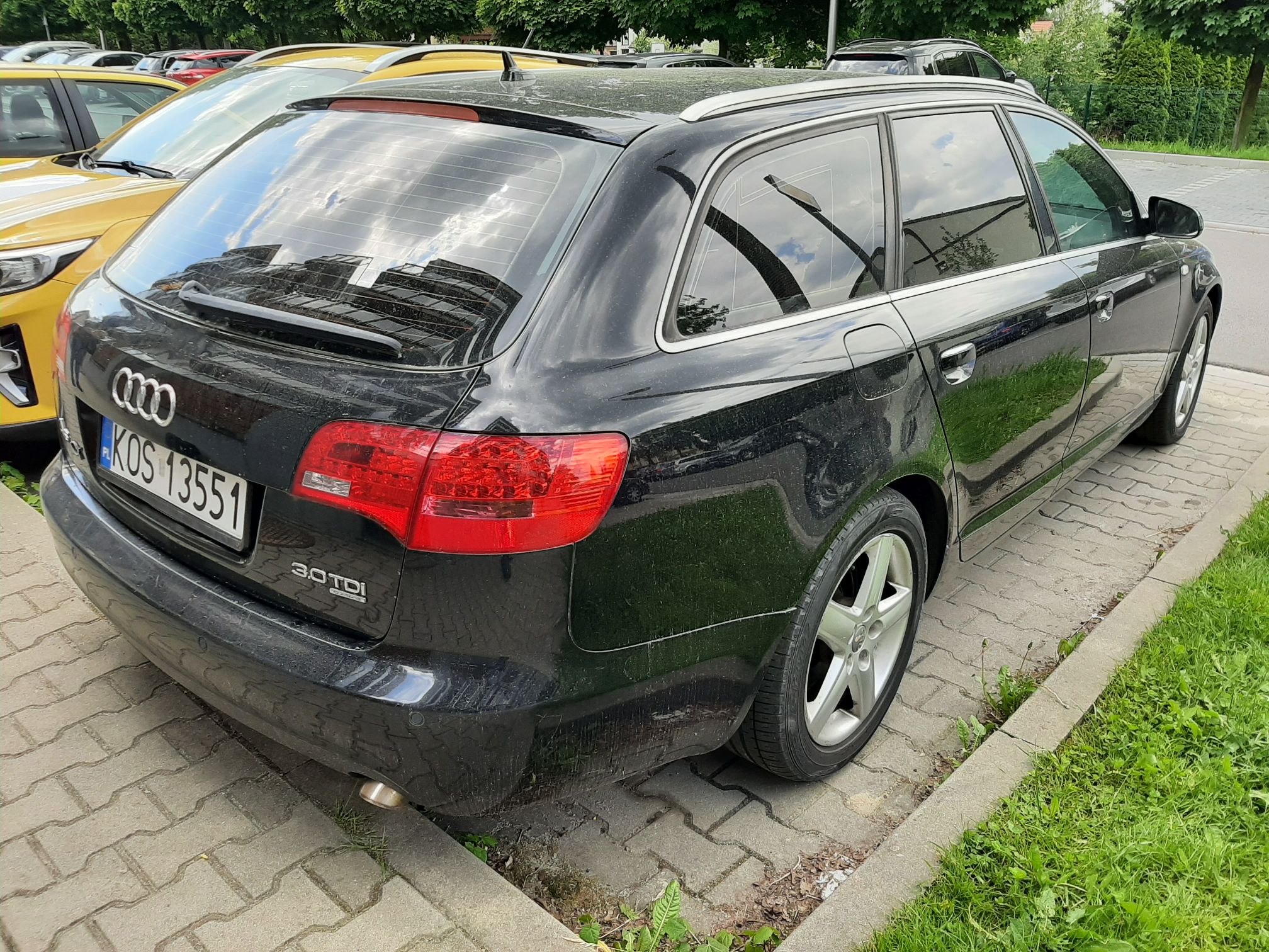 Czarny samochód Audi kombi z widocznym tyłem i prawym bokiem pojazdu oraz przyciemnionymi szybami