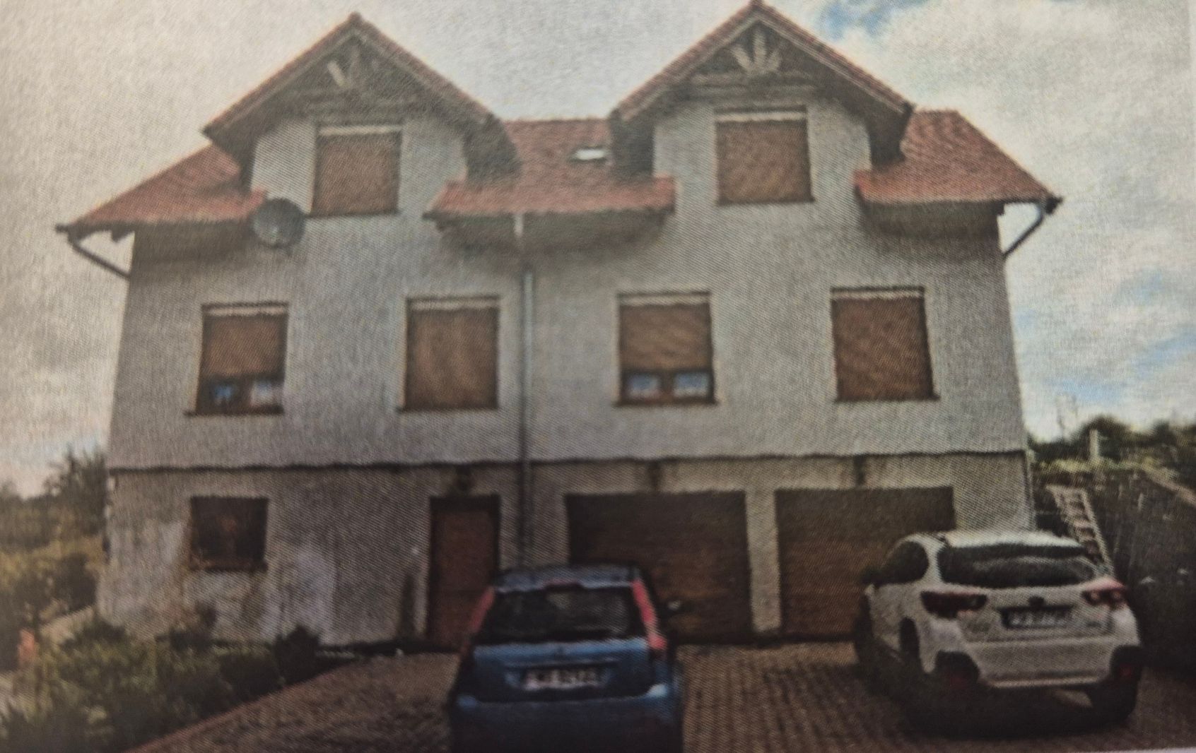 Budynek mieszkalny 3 kondygnacyjny. Po prawej stronie dwa wjazdy do garażu.