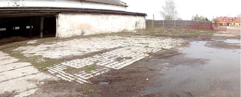 Część budynku i widoczny przed nim plac.