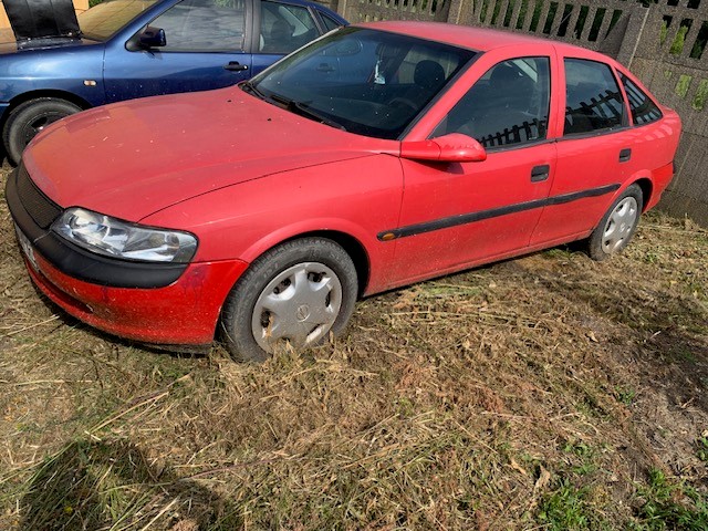 Zdjęcie przedstawia samochód Opel Vectra B w wersji nadwozia typu liftback (5-drzwiowy) w kolorze czerwonym.