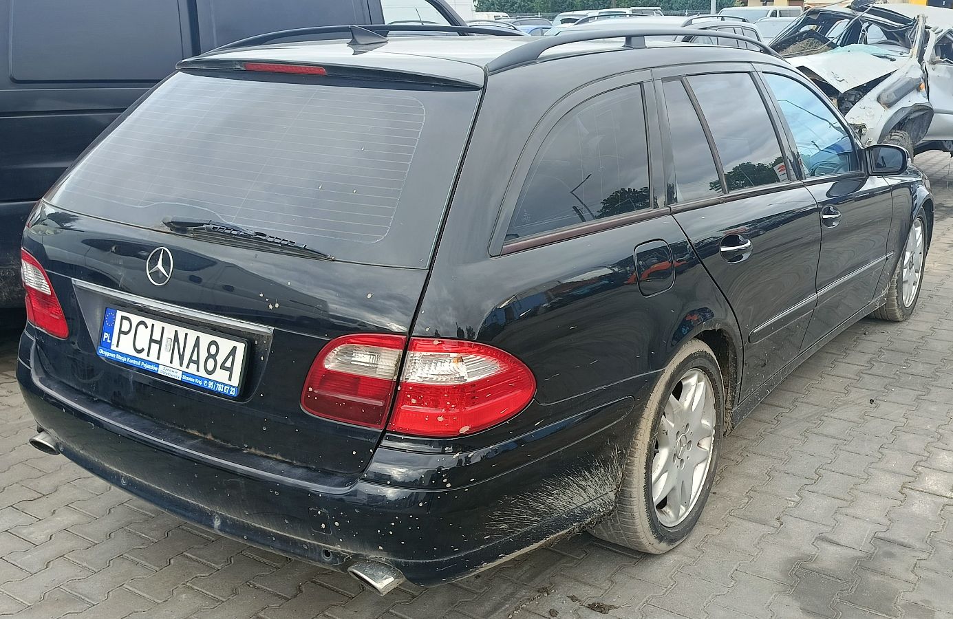 prawy bok granatowego Mercedesa E320 CDI, z widocznymi przetarciami lakieru