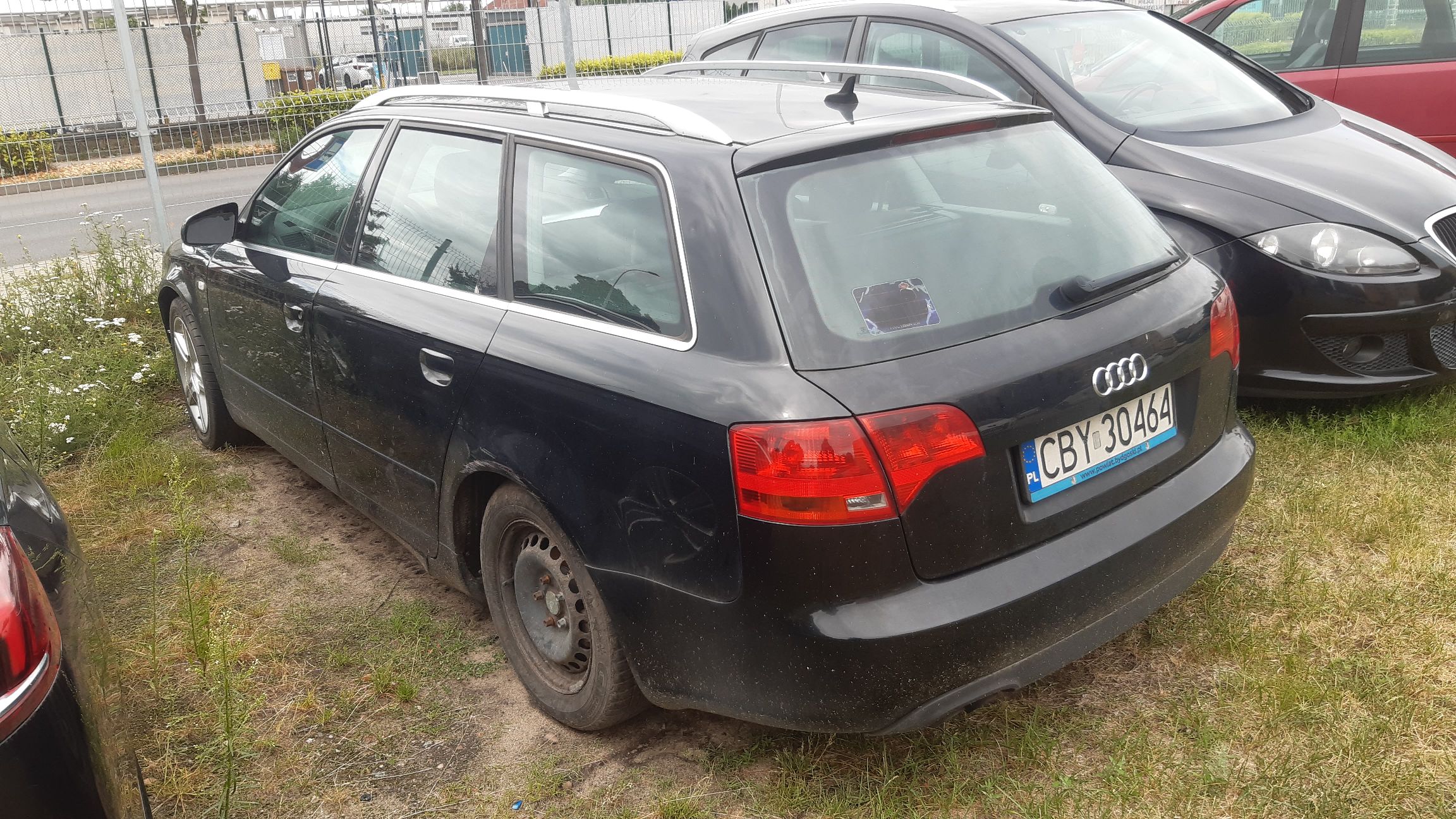 Czarny samochód Audi A4 Avant w wersji kombi, widok z tyłu z lewej strony