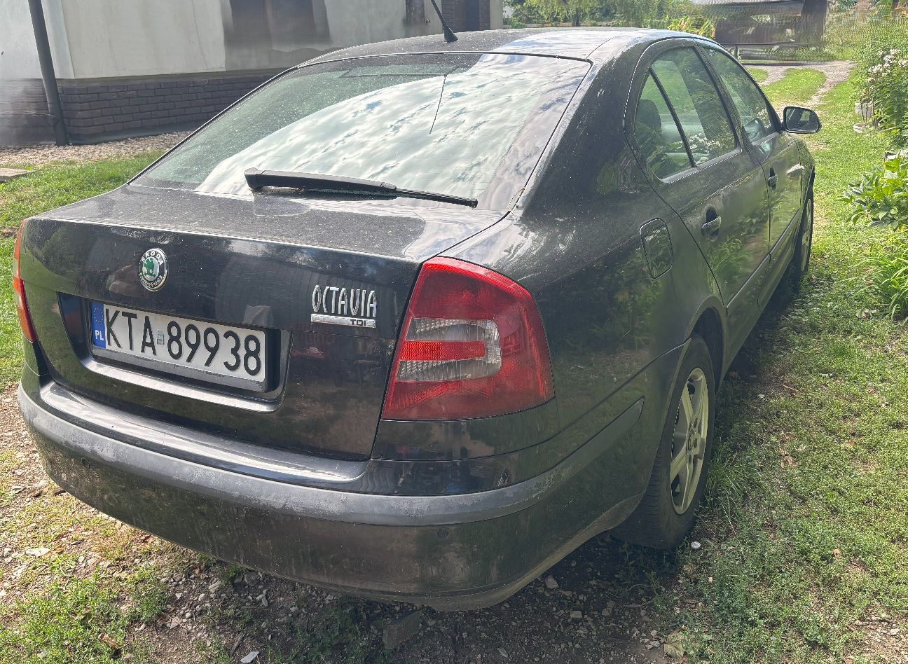 Tył czarnej Skody Octavii II pokazujący prawy profil auta, stan lakieru na zderzaku oraz aluminiowe felgi od prawej strony.