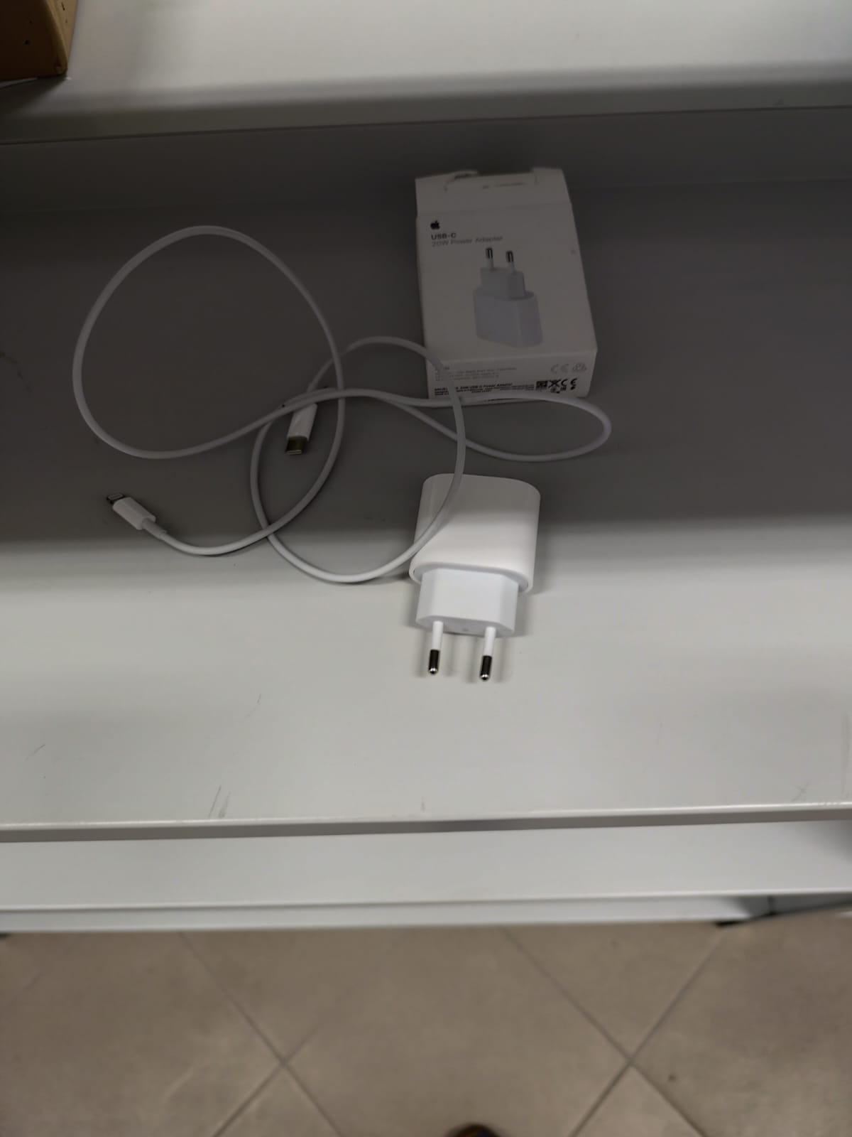 Biała ładowarka sieciowa 20 W z europejską wtyczką, kabel USB-C oraz małe, białe pudełko z logo Apple.