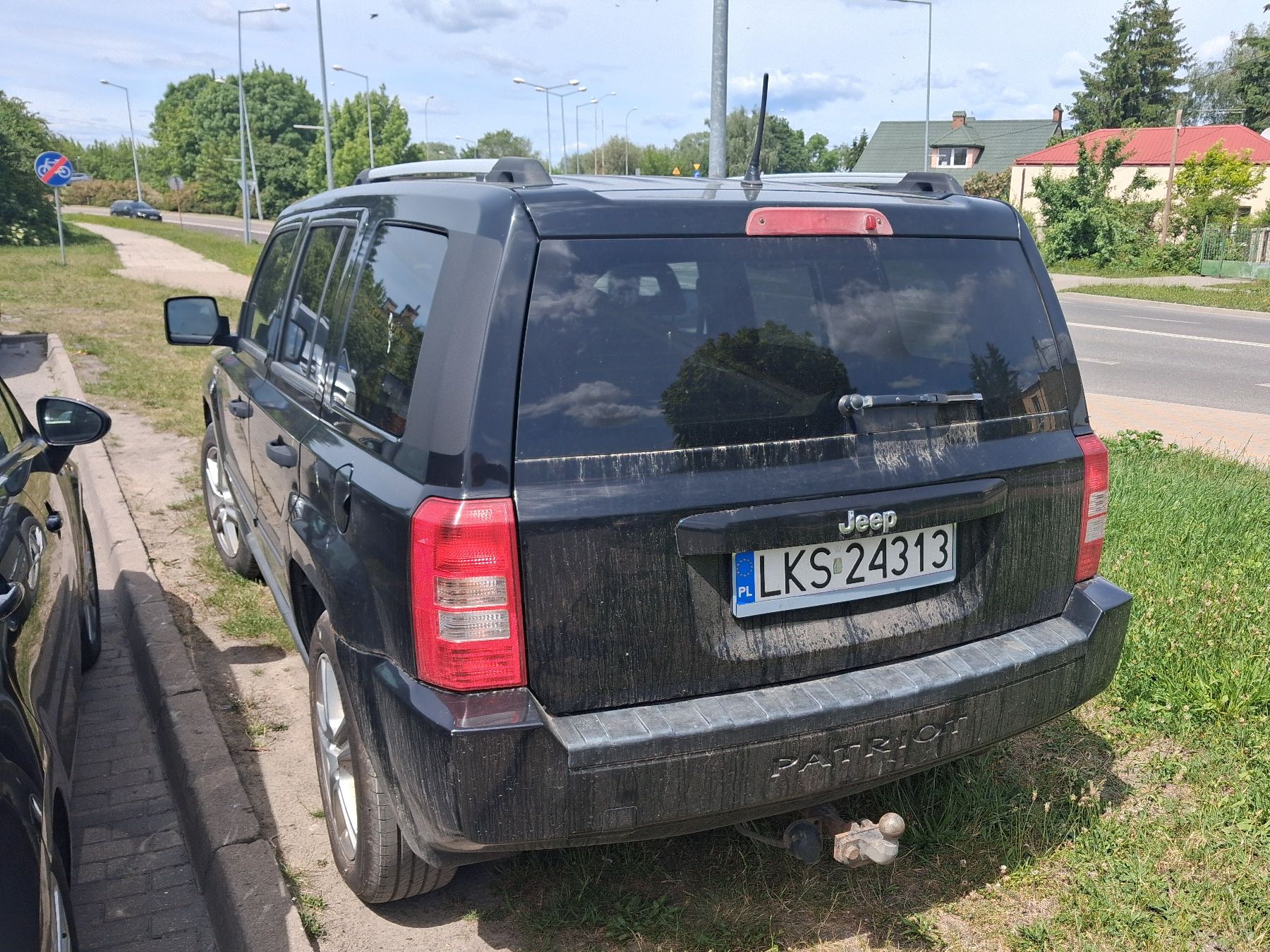 Czarny samochód terenowy Jeep sfotografowany z tyłu, widoczny hak holowniczy