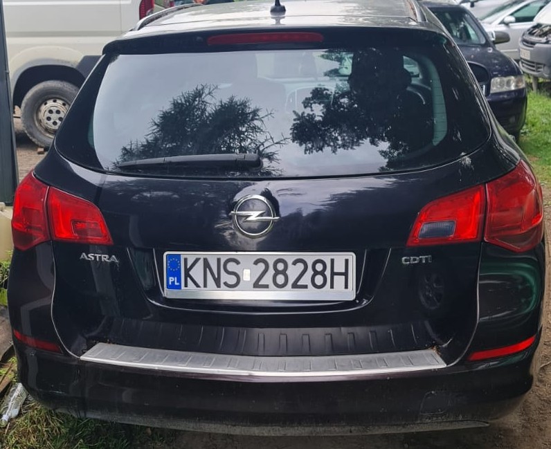 Tył granatowego pojazdu marki Opel Astra z polską tablicą rejestracyjną.