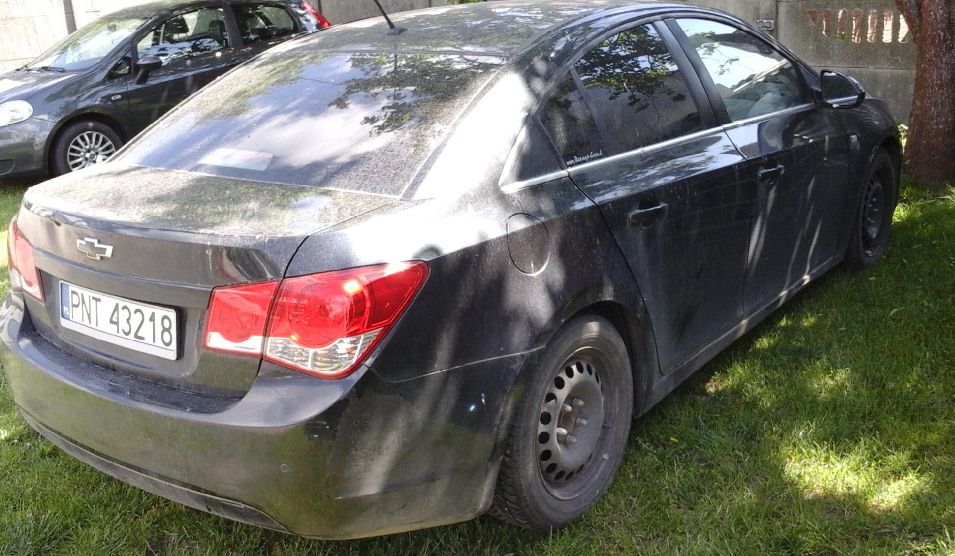 Czarny samochód osobowy marki Chevrolet Cruze w wersji sedan, zaparkowany tyłem.