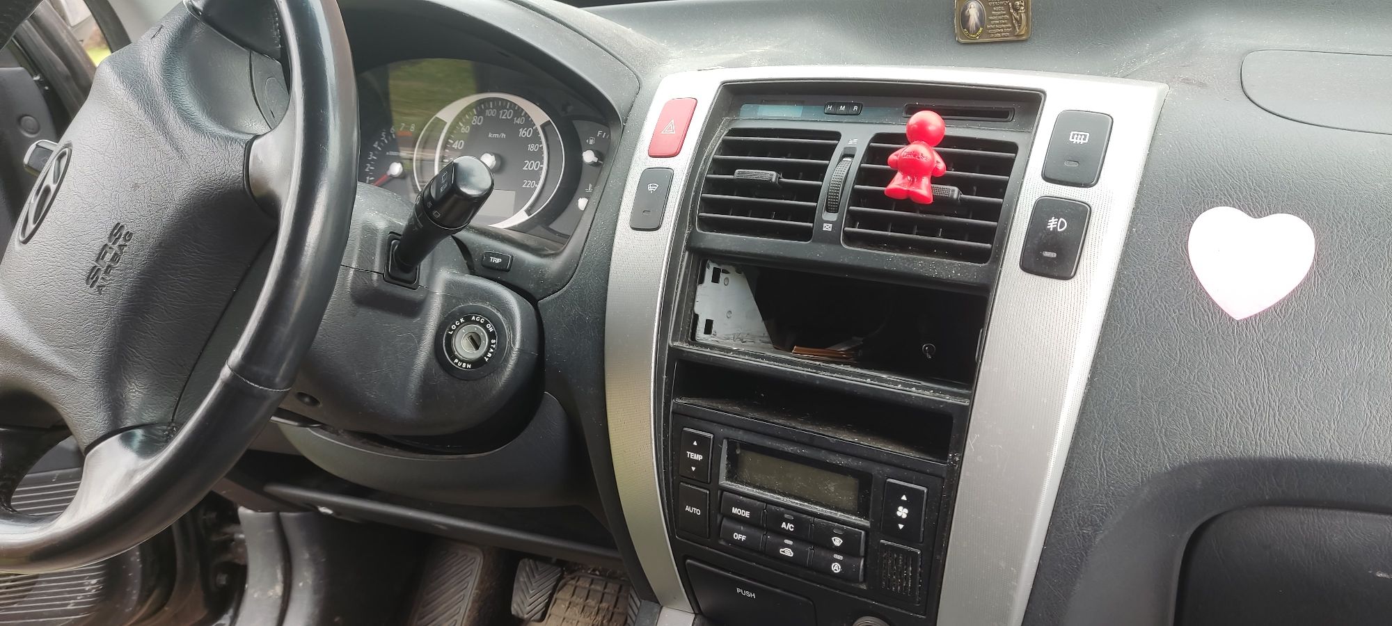 Panel sterujący koloru srebrnego, z widocznym pustym miejscem przeznaczonym na radio.