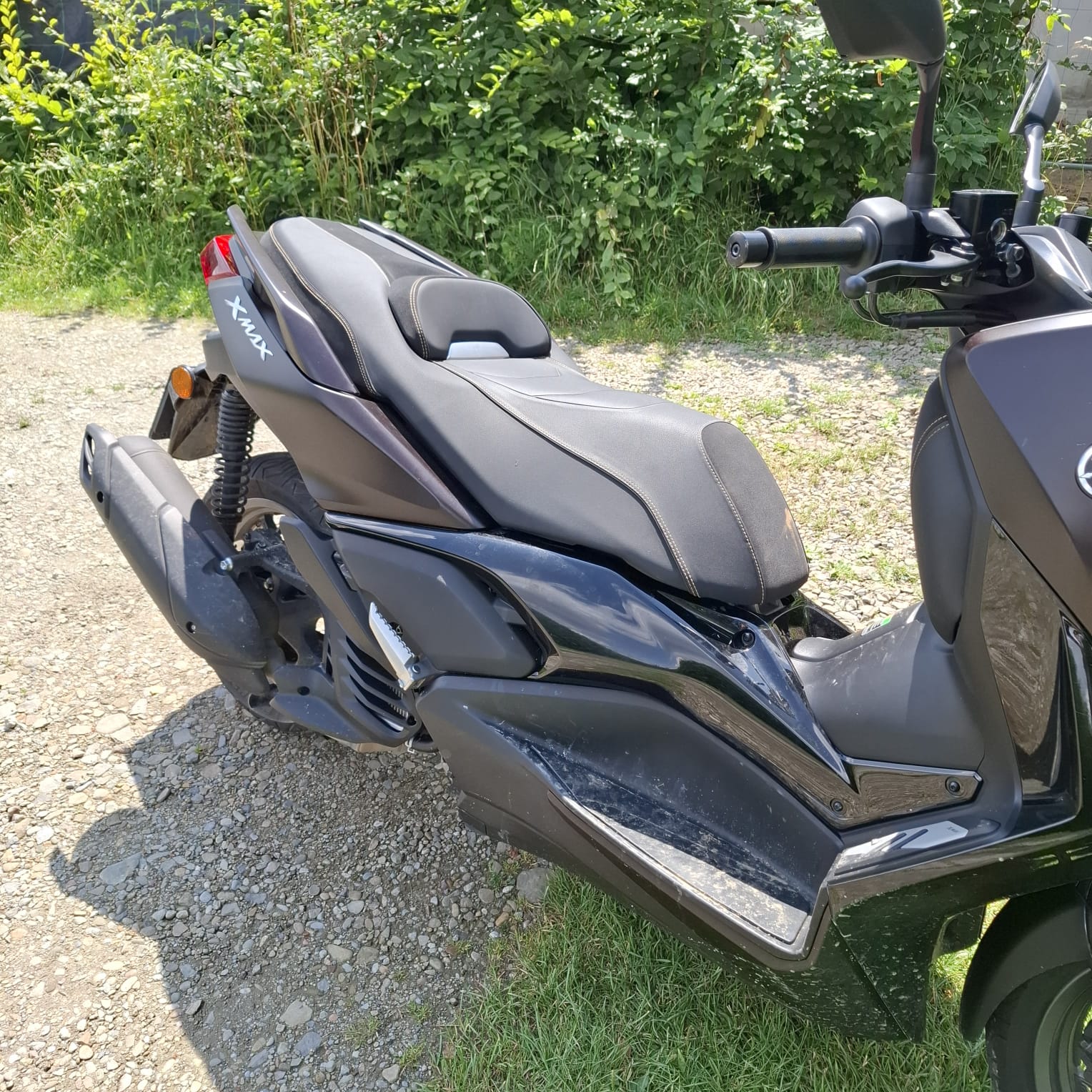 Prawy bok czarnego skutera Yamaha.