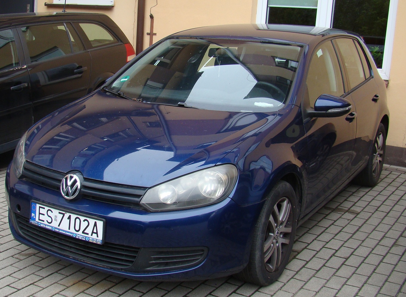 Granatowy samochód osobowy marki Volkswagen Golf. W przednich drzwiach od strony pasażera brak szyby.