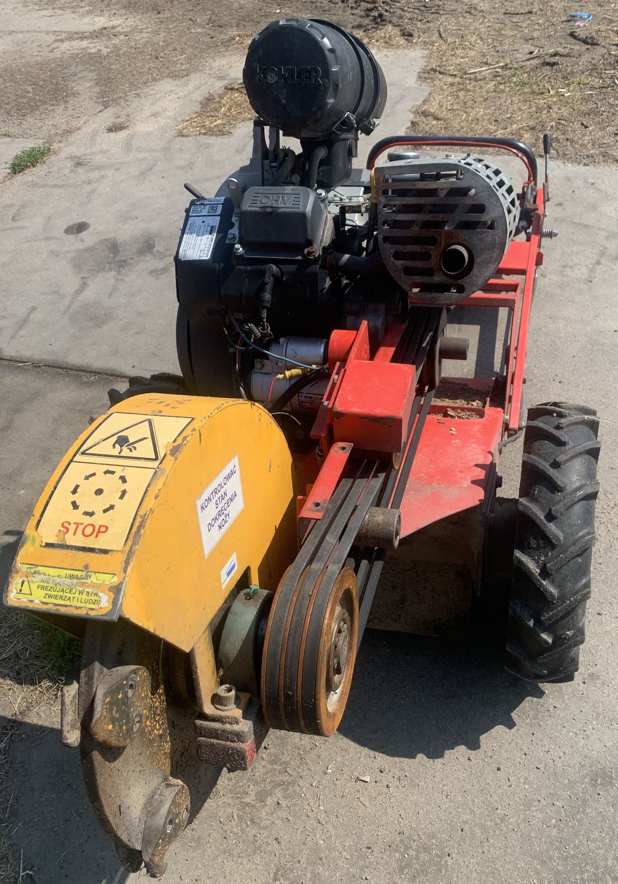 Czerwona frezarka do pni Teknamotor Skorpion F-400 z silnikiem Kohler, czarnymi kołami i tarczą tnącą z przodu