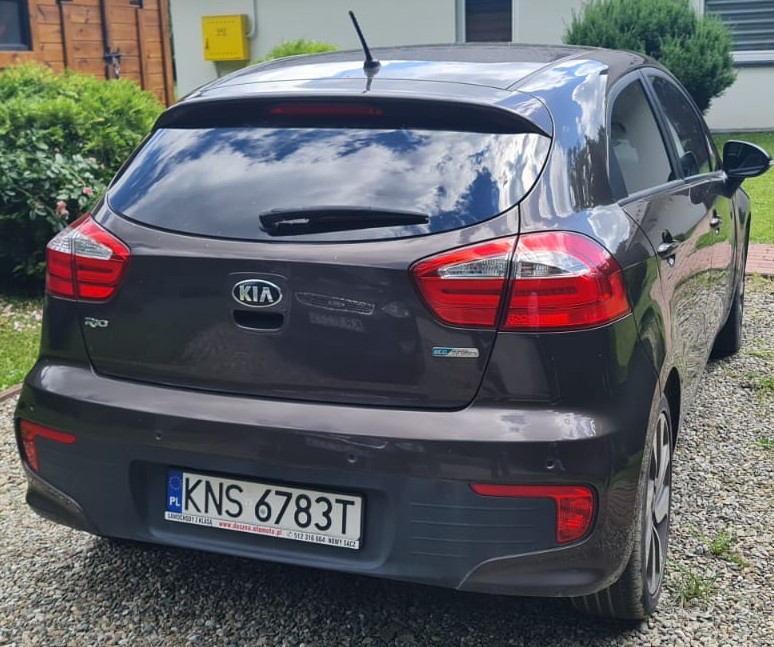 Brązowy Kia Rio, widok z tyłu, z wyraźnymi liniami nadwozia i sportowym wyglądem.