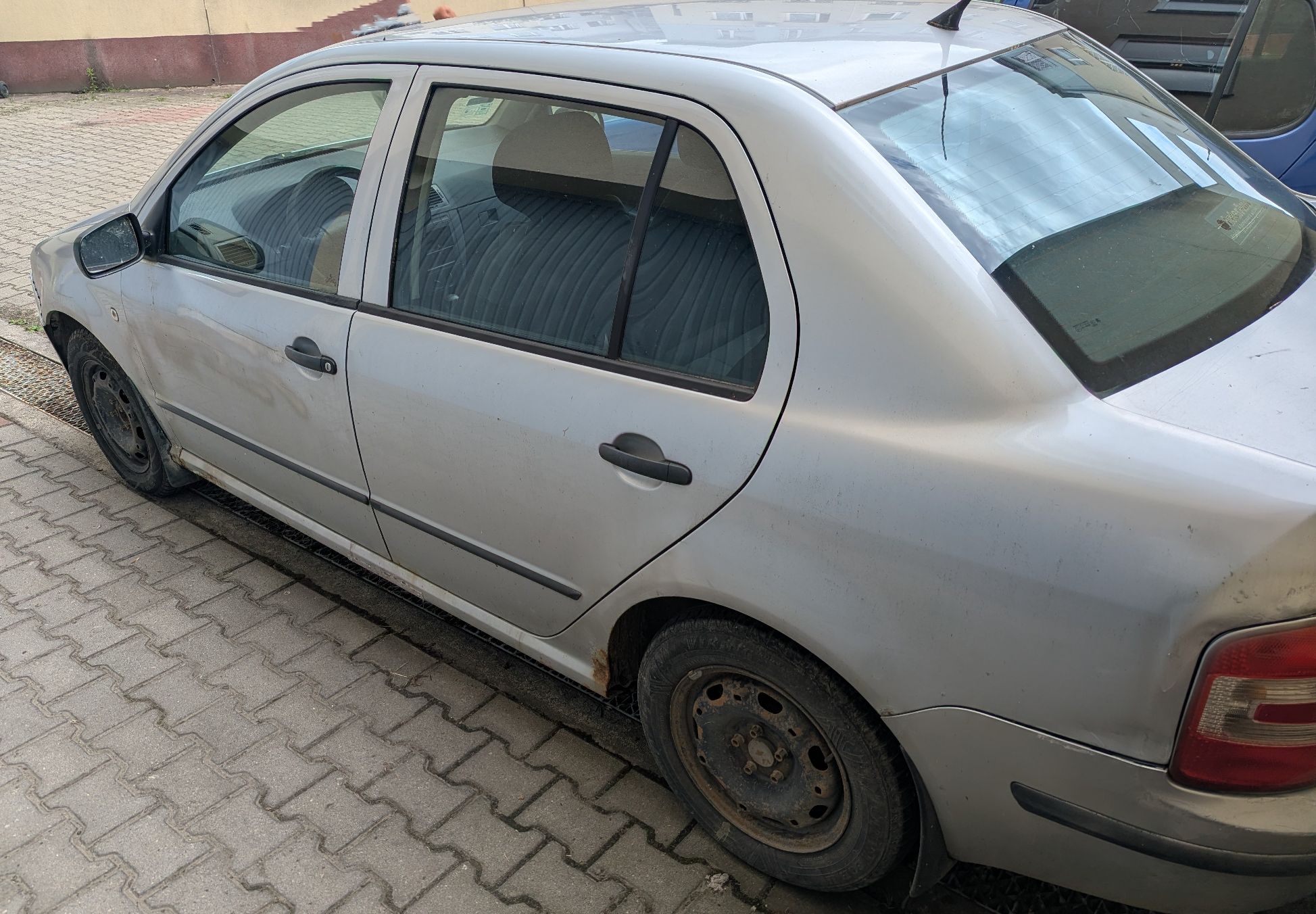 Lewa storna srebrnego samochodu Skoda Fabia. Na progu oznaki korozji oraz napraw blacharsko lakierniczych