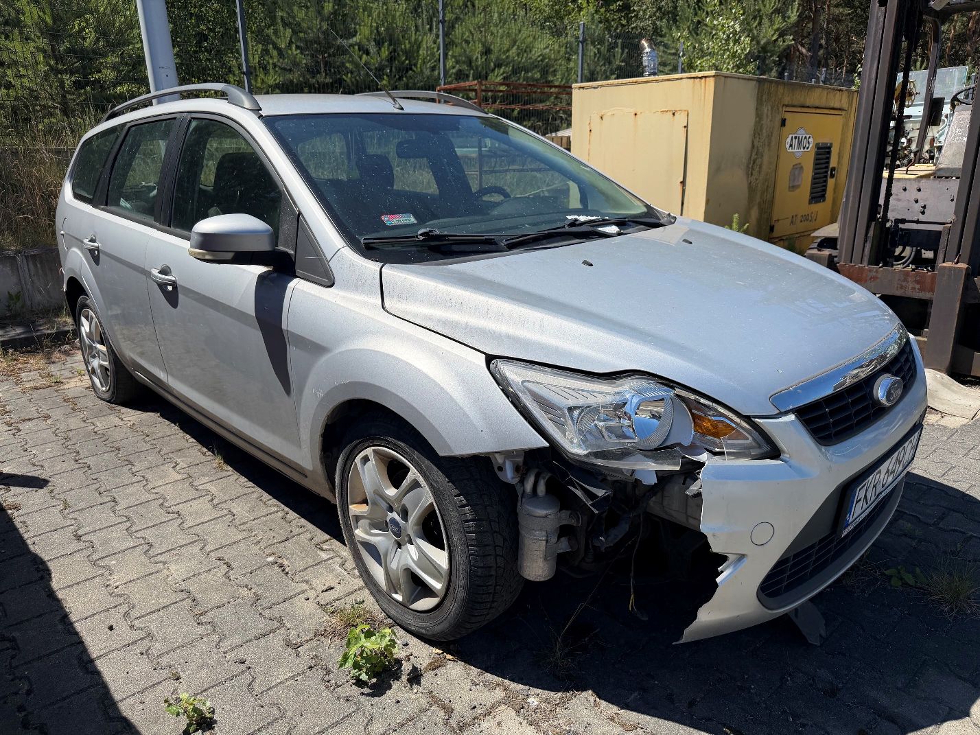Srebrny Ford Focus, widok prawego przodu, uszkodzona prawa strona przedniego zderzaka, uszkodzona przednia prawa lampa