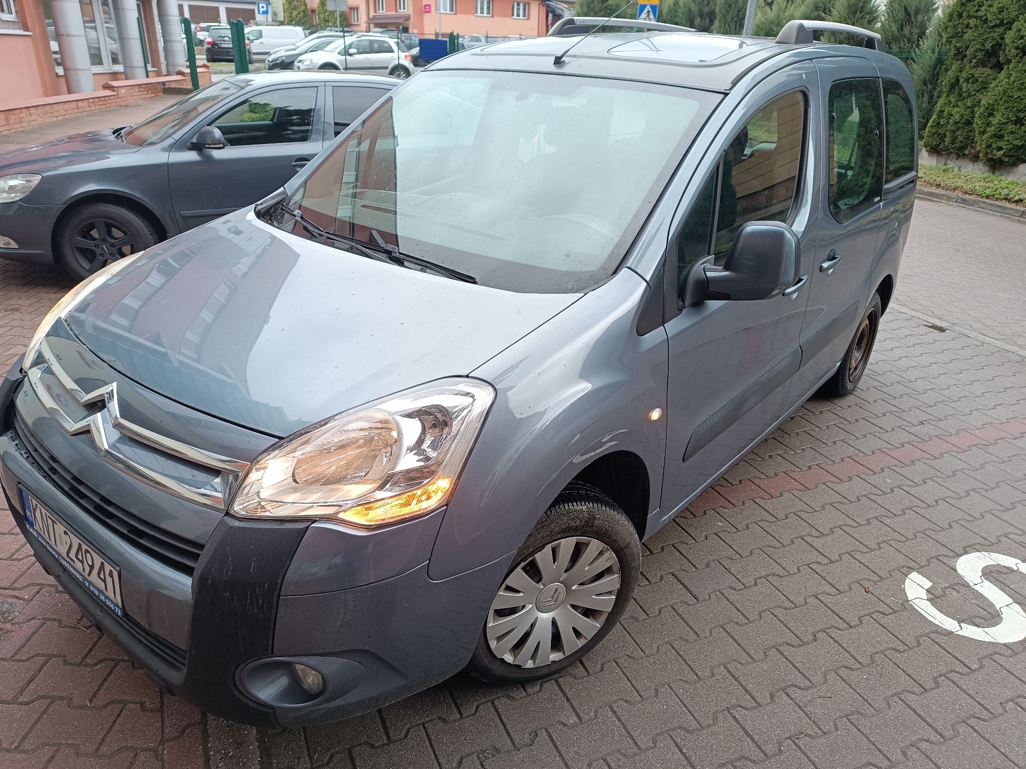 Samochód osobowy Citroën Berlingo z włączonym lewym kierunkowskazem, widoczna tablica rejestracyjna
