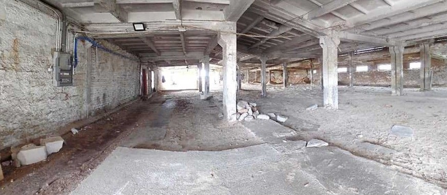 Puste, betonowe wnętrze starej hali.