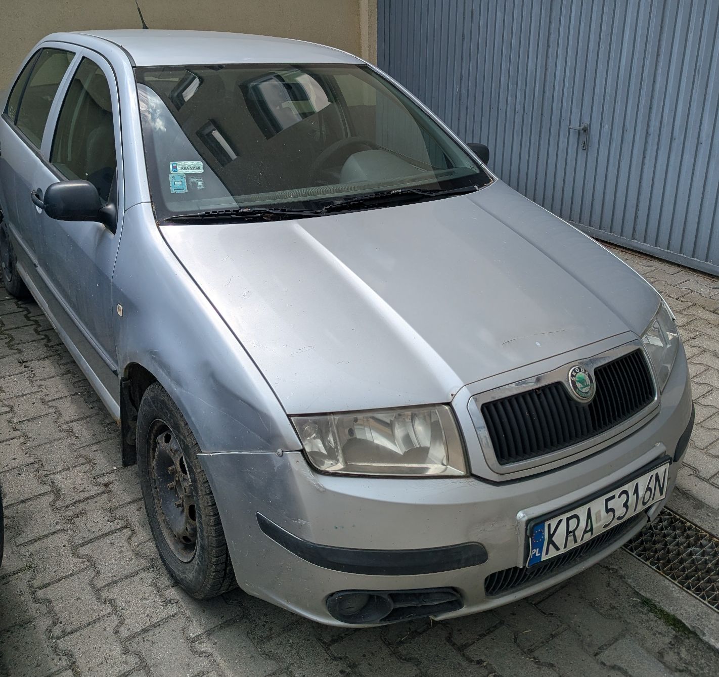 Prawa strona srebrnego samochodu osobowego Skoda Fabia. Na progu oznaki korozji oraz napraw blacharsko lakierniczych