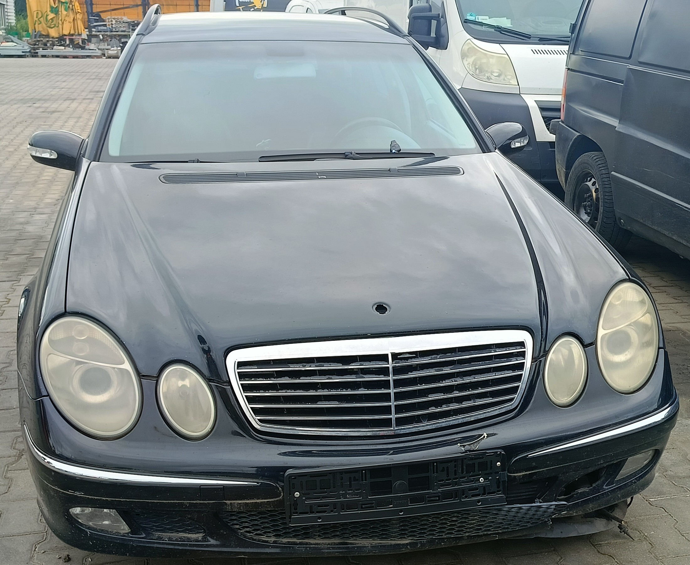 przód granatowego Mercedesa E320 CDI, z widocznym uszkodzonym zderzakiem