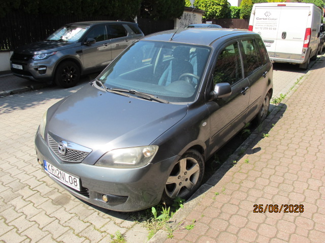 Przód i lewy bok pojazdu Mazda 2 koloru szarego.