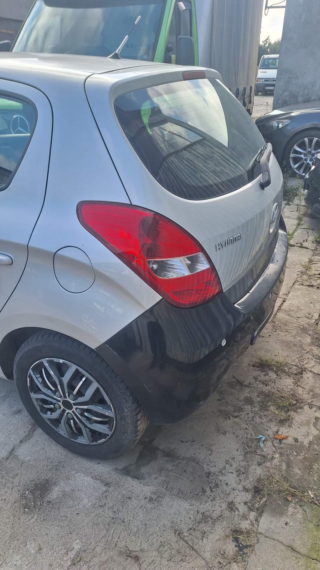 Samochód Hyundai i20 w kolorze szarym widoczny od tyłu z lewej strony.