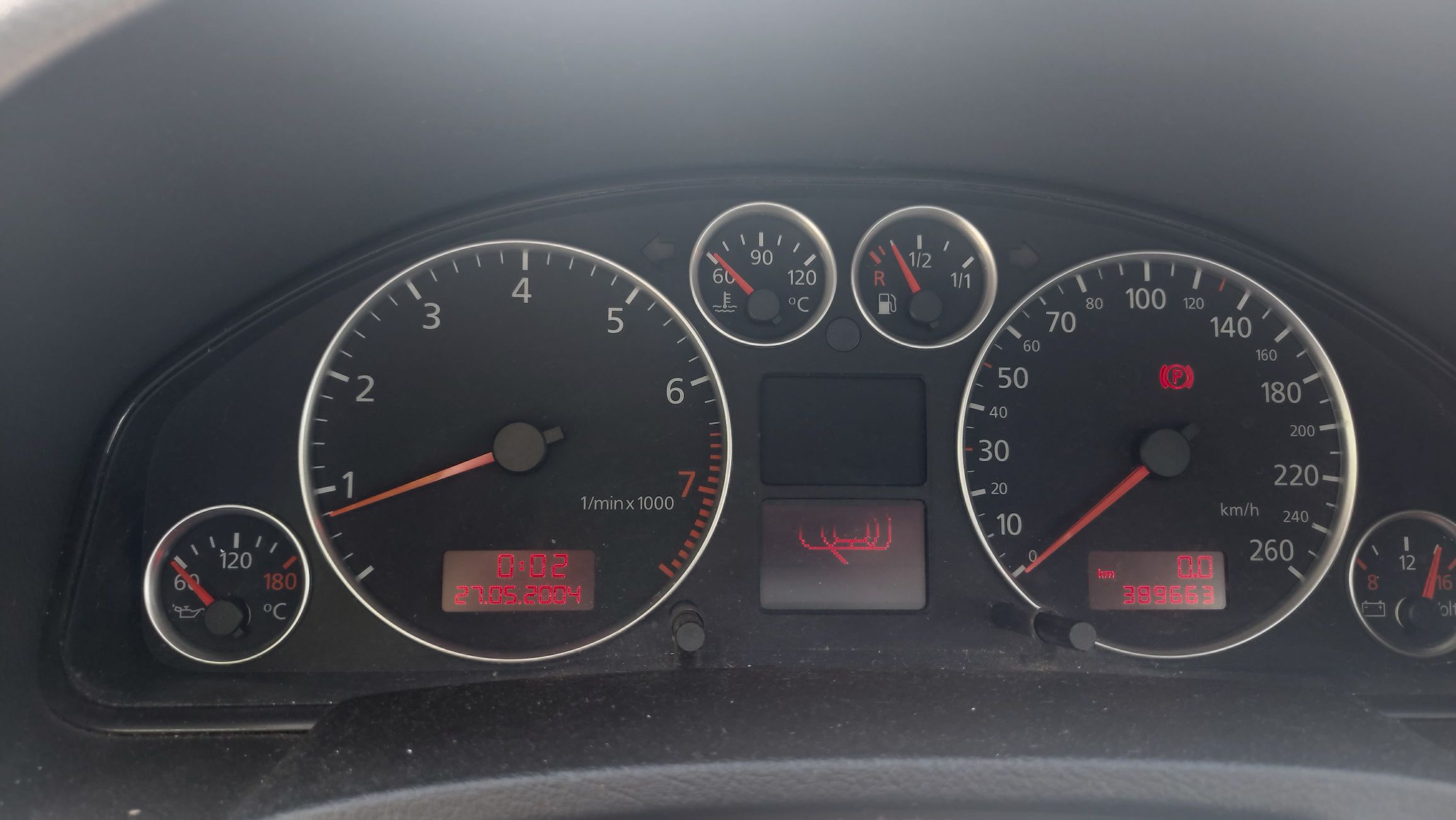 Deska rozdzielcza Audi A6 C5 z widocznymi wskaźnikami oraz podświetlony przebieg 389633 km.