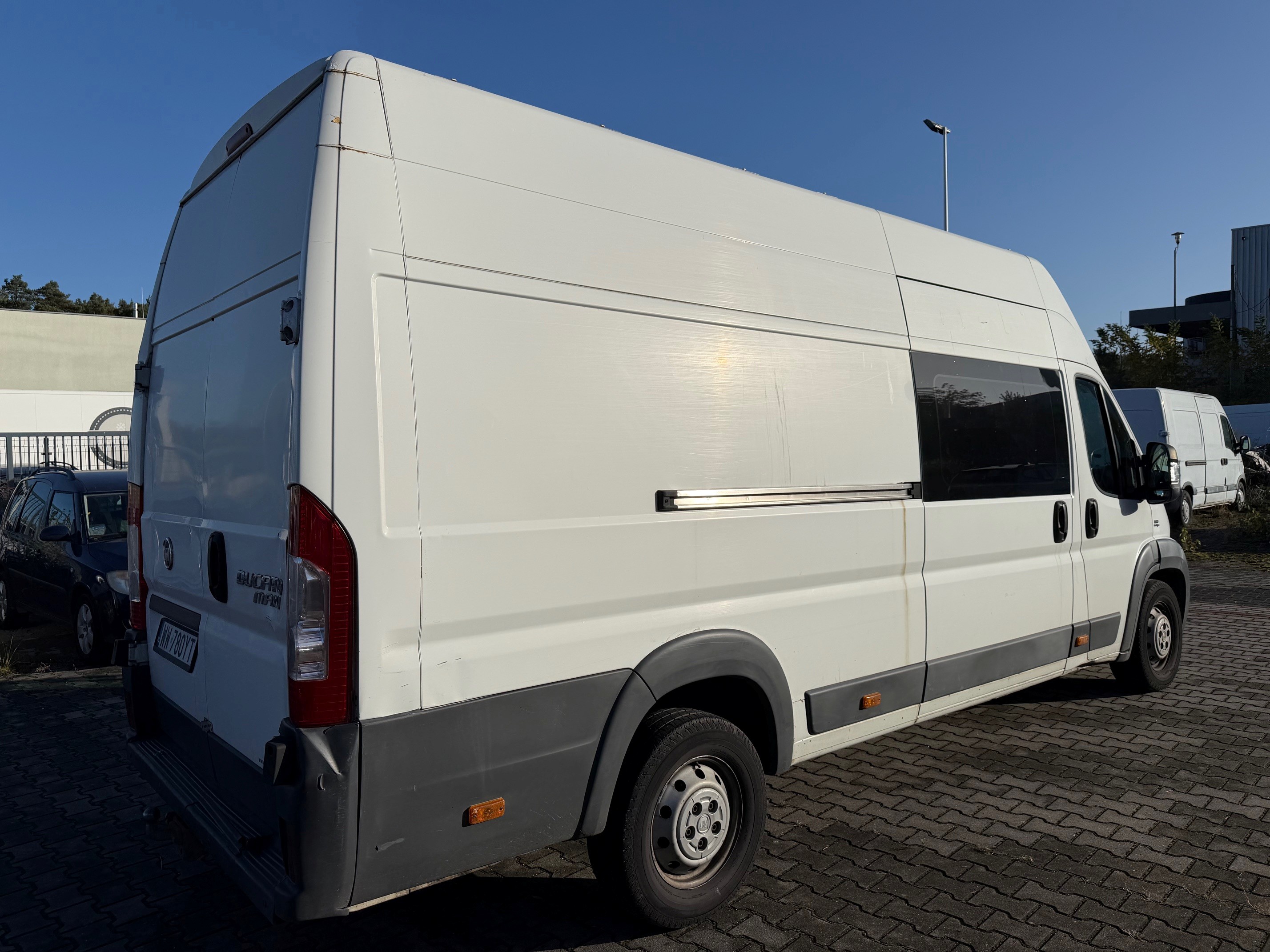Biały Fiat Ducato, ujęcie prawej strony i tyłu pojazdu.