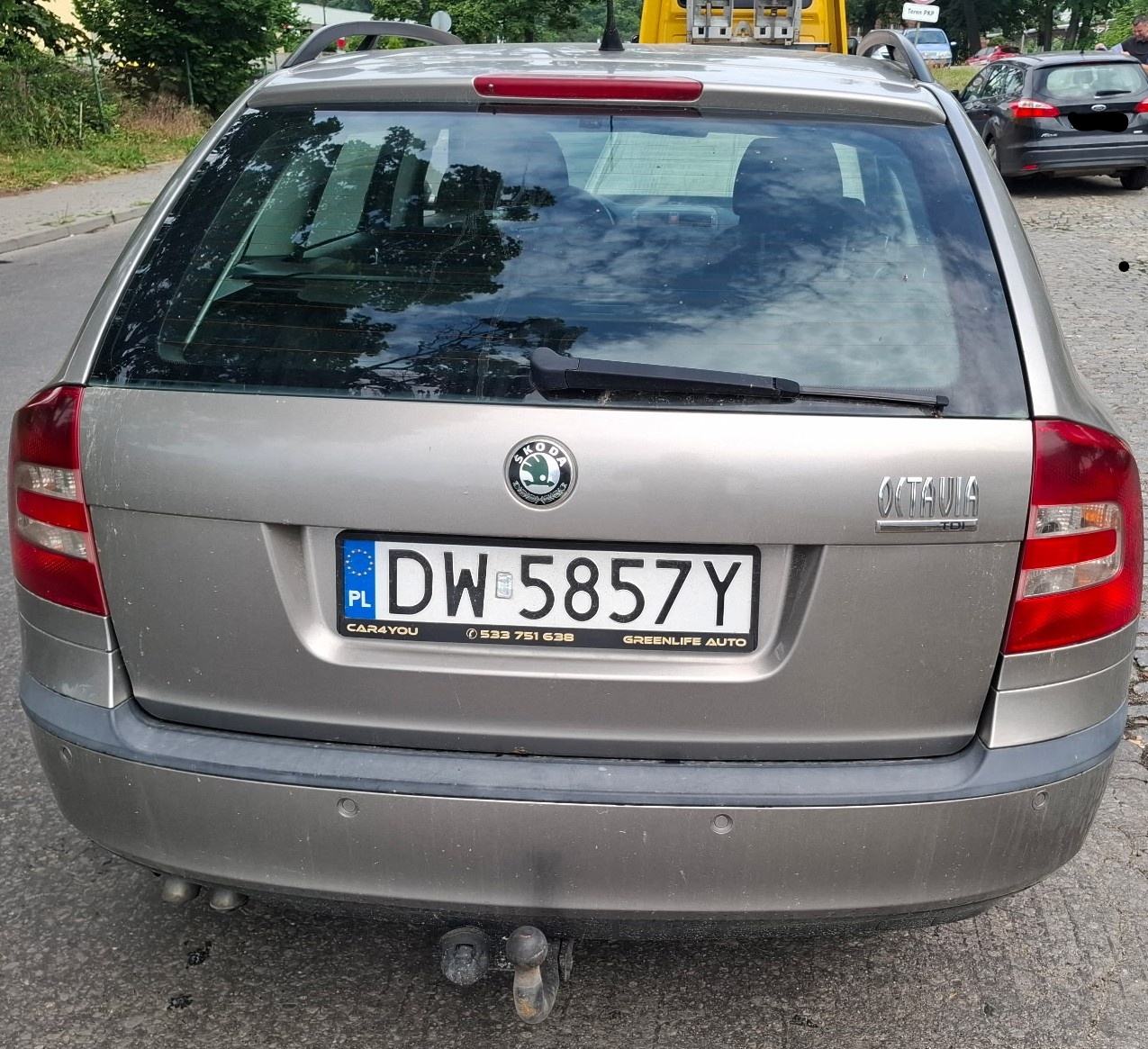 Skoda Octavia kombi, widok z tyłu, z widoczną klapą bagażnika i hakiem holowniczym.