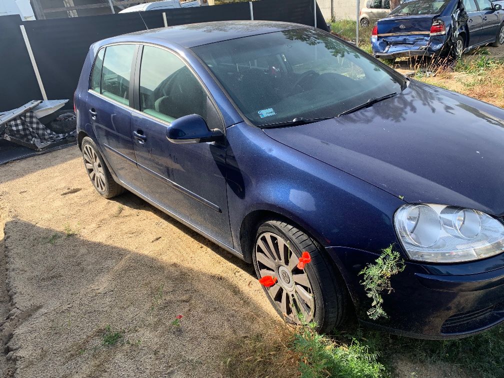 Granatowy samochód osobowy marki Volkswagen, model Golf V - widok z prawej strony