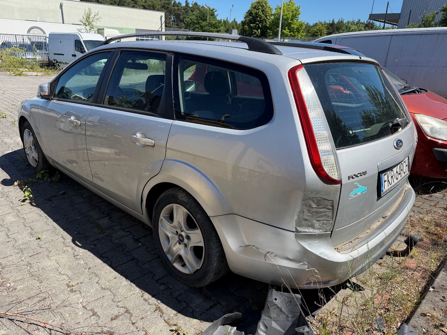 Srebrny Ford Focus, widok lewego tyłu, wgniecenie tylnego błotnika oraz lewej strony tylnego zderzaka