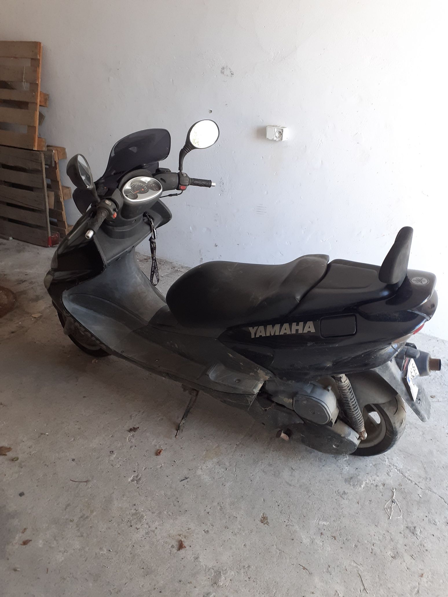 Czarny motorower Yamaha Majesty widok od boku, z profilowaną kanapą, oparciem pasażera i widocznym logotypem na obudowie.