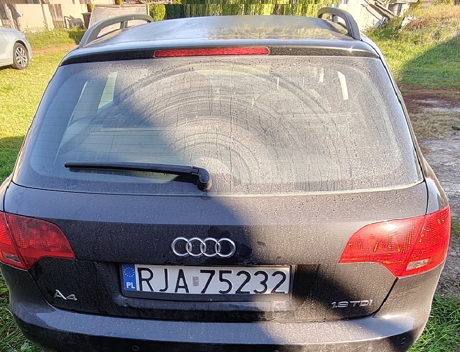 Samochód Audi A4 w kolorze czarnym widoczny od tyłu.