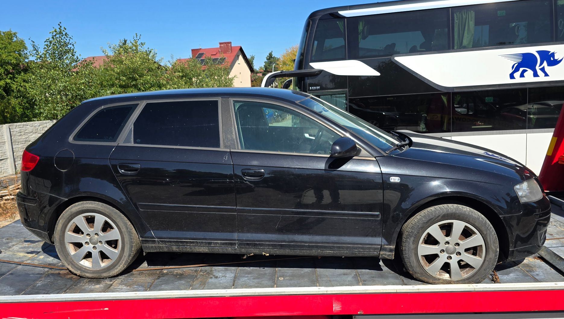 Granatowy samochód Audi A3. Widok od strony prawego profilu.
