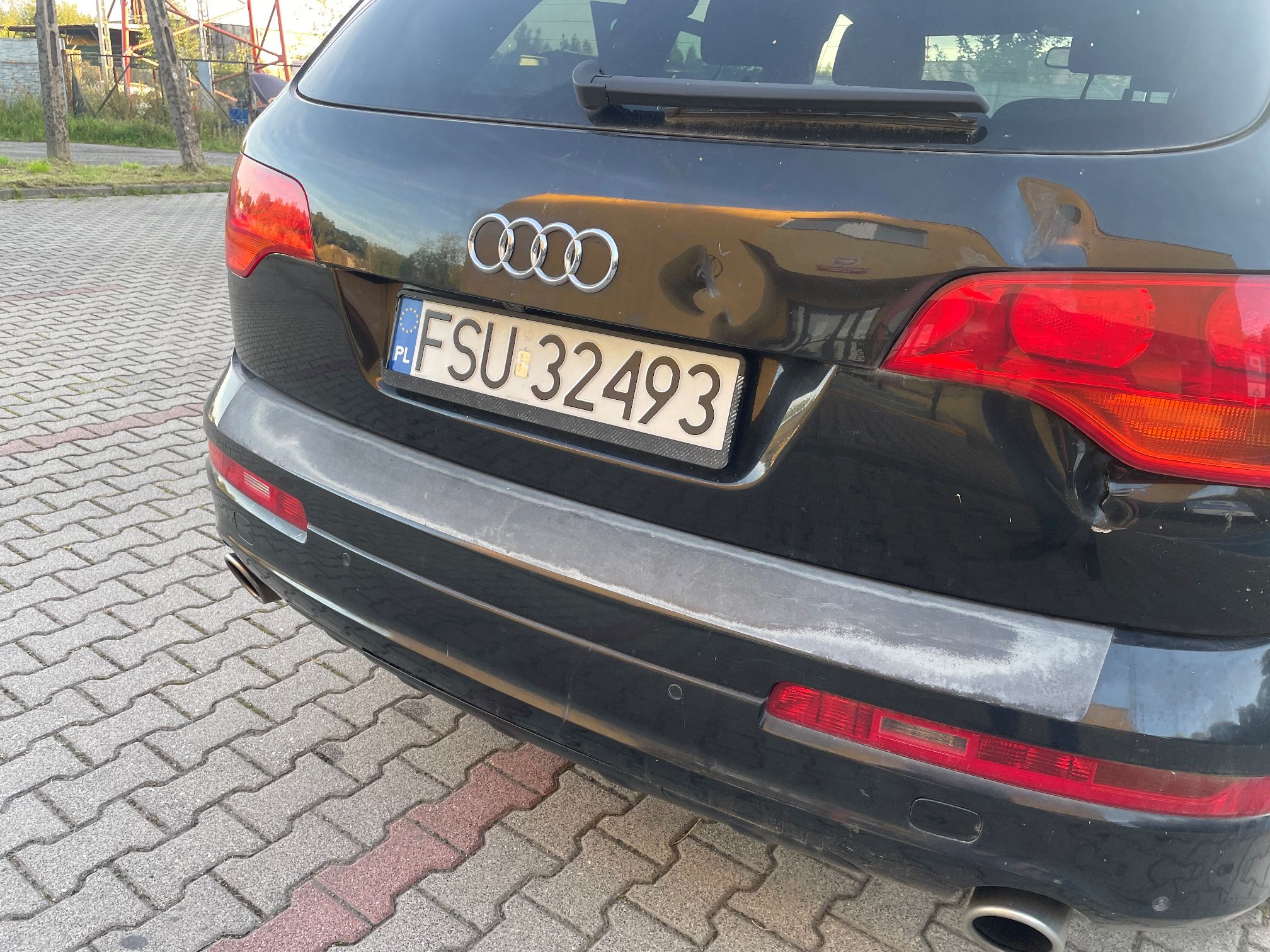 Tył pojazdu Audi Q7. Widoczne wgnicenie w tylnej klapie w okolicy lamp.