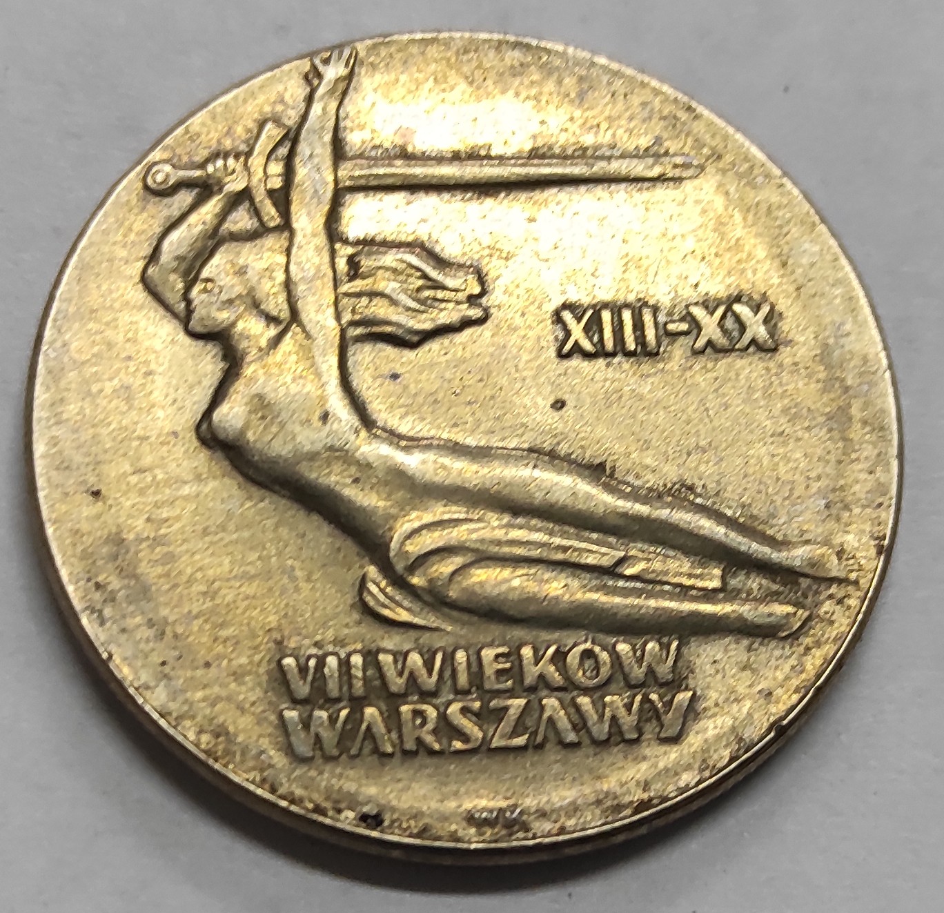 Rewers monety z wizerunkiem NIKE oraz napisem VII wieków Warszawy