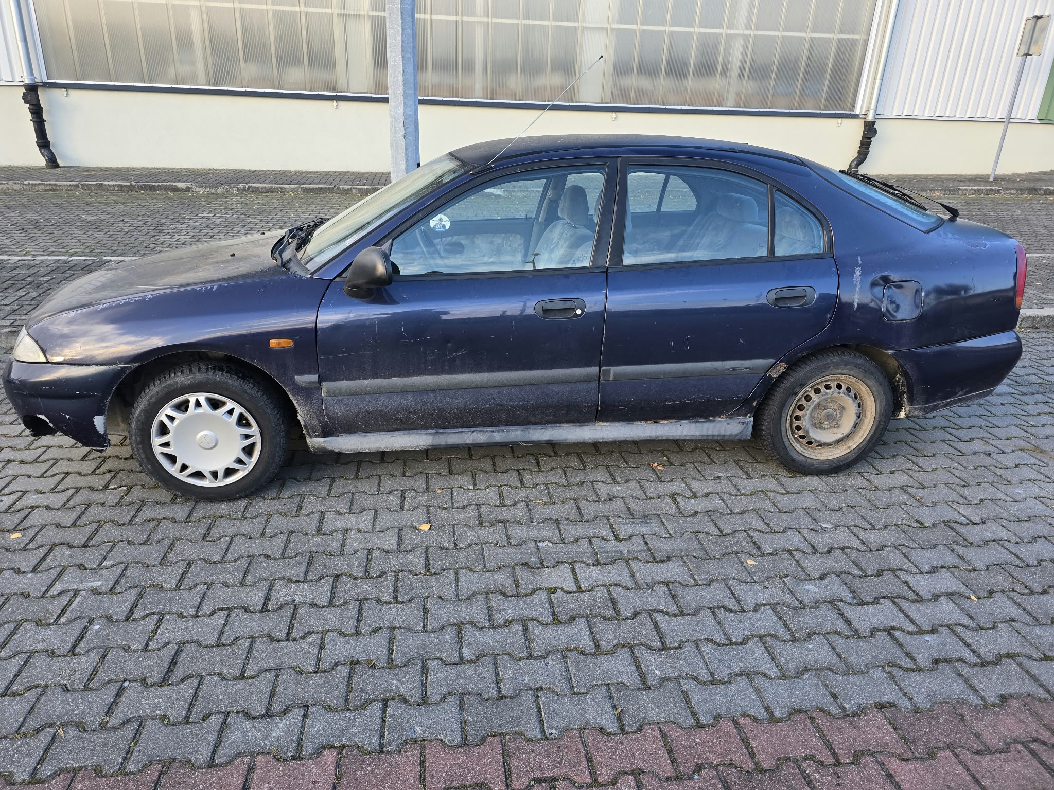 lewa strona pojazdu koloru granatowego, liczne oznaki korozji na karoserii, wgniecenie przy wlewie do paliwa