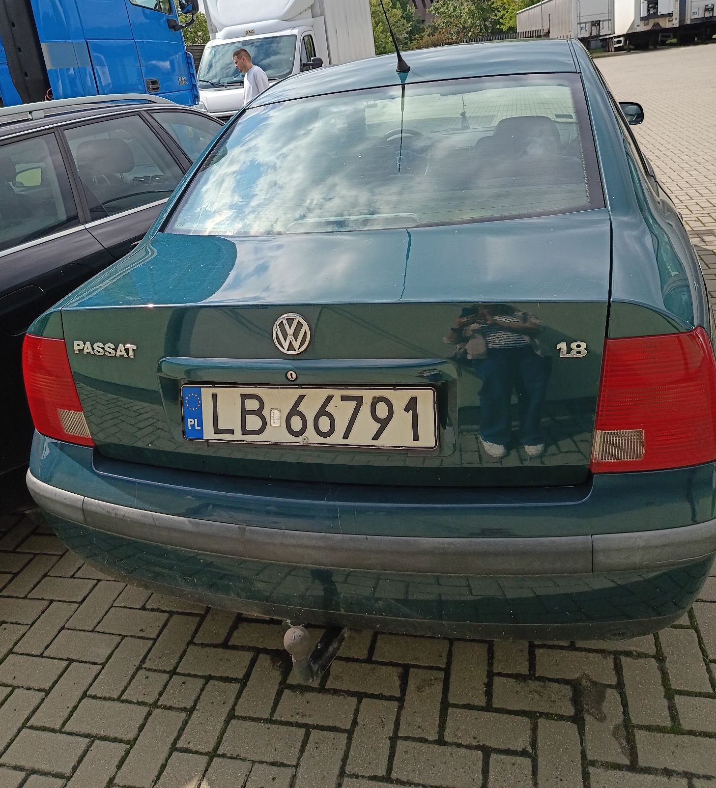 Tylna klapa z emblematem Volkswagen i napisem Passat 1.8; tylne lampy bez widocznych uszkodzeń; zderzak tylny, hak holowniczy