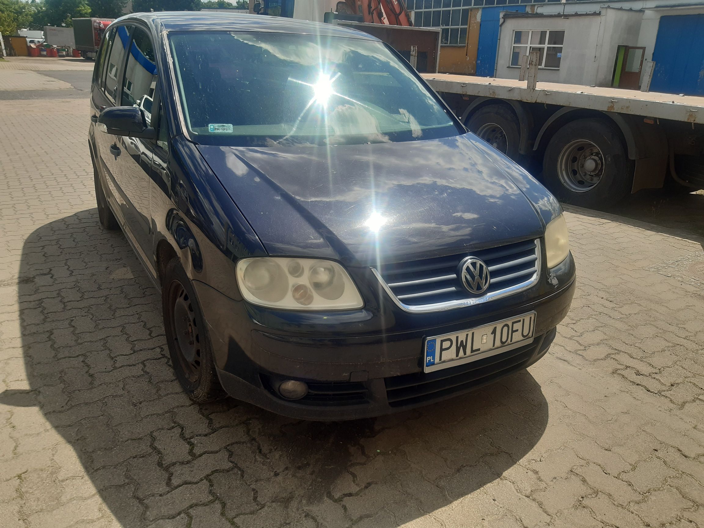 Ciemnogranatowy Volkswagen Touran prezentowany od przodu