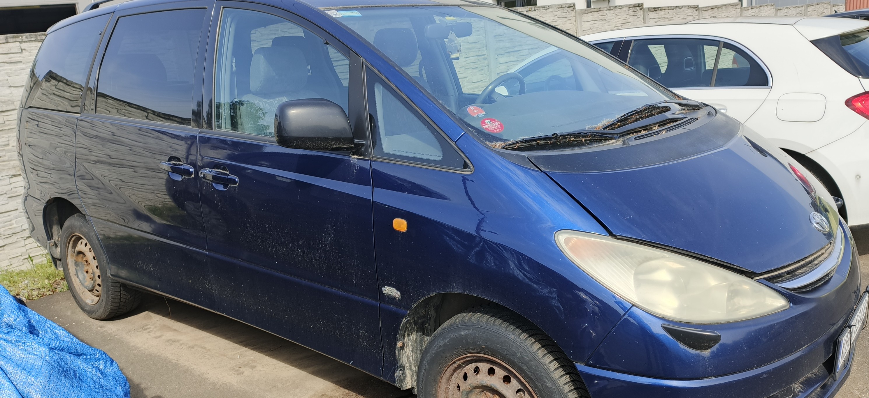 Prawy bok samochodu Toyota Previa. Kolor pojazdu granatowy.