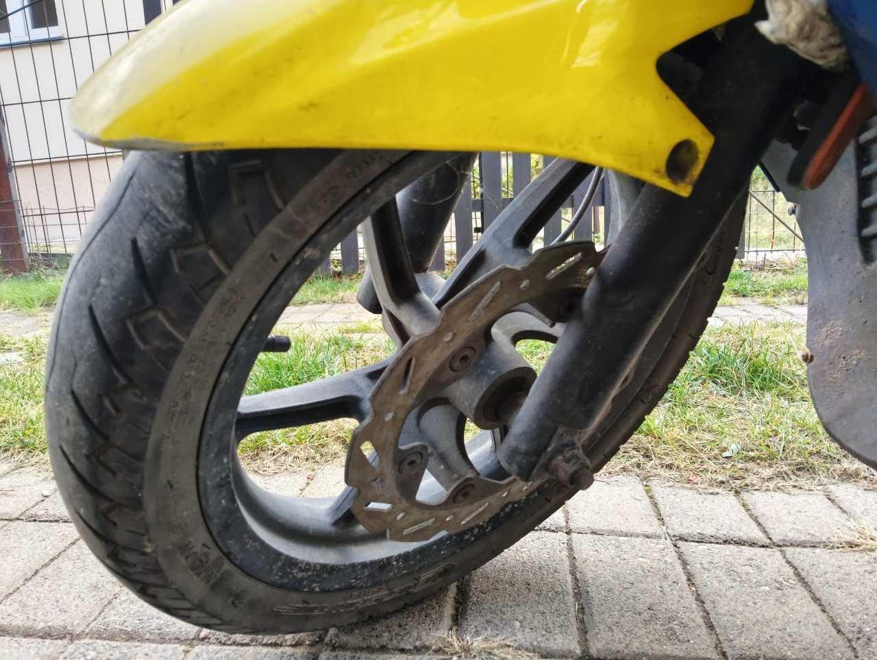 Przednia tarcza hamulcowa zamontowana do piasty koła, brak zacisku hamulca i klocków.