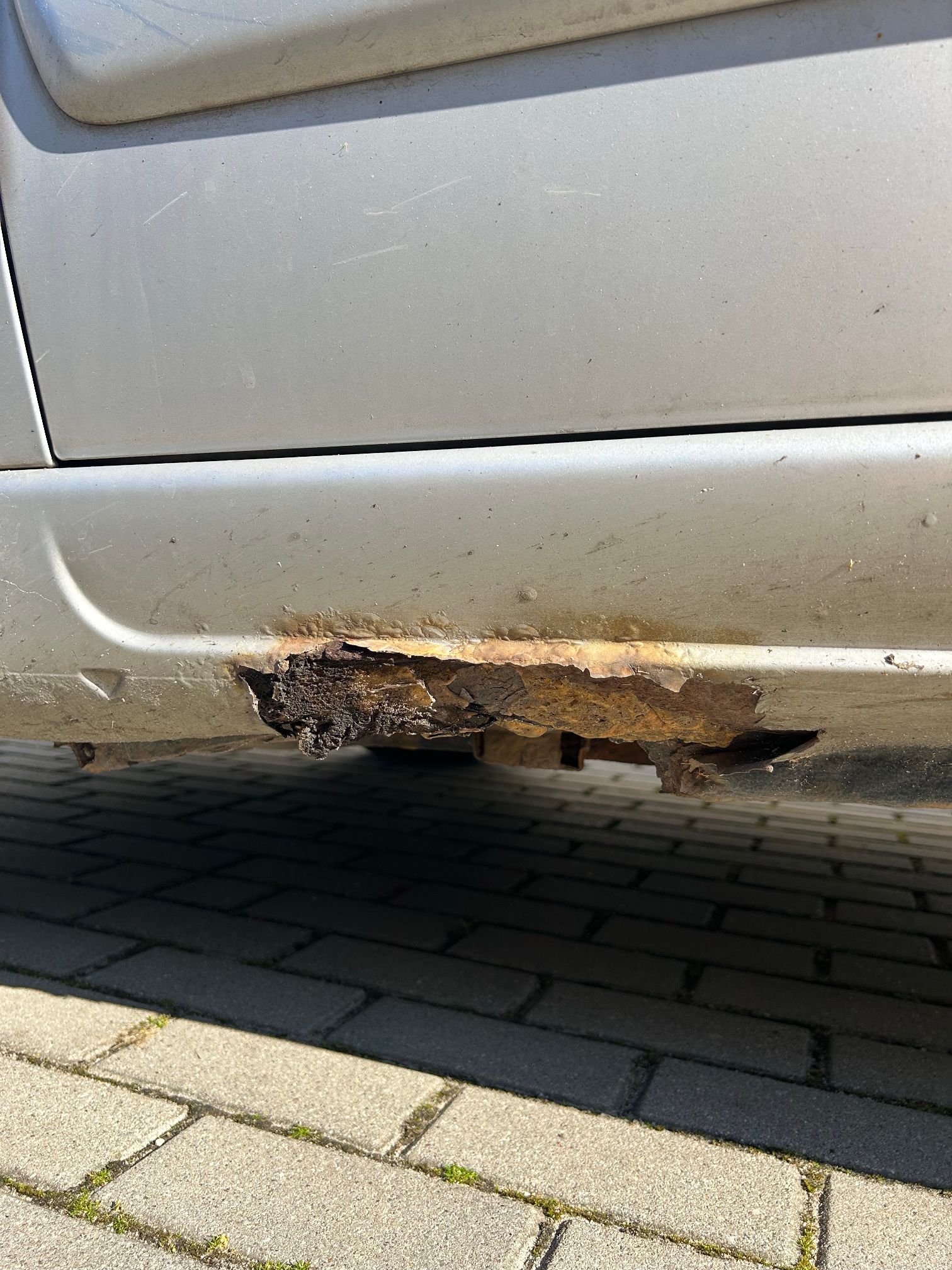 Próg pojazdu z widocznymi ogniskami korozji.