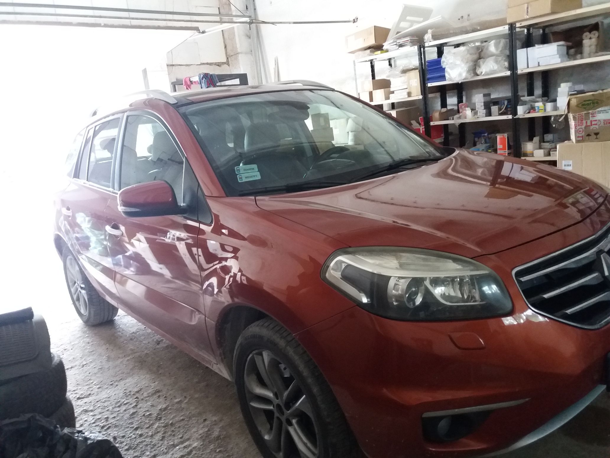Prawy bok i przód czerwonego samochodu Renault Koleos
