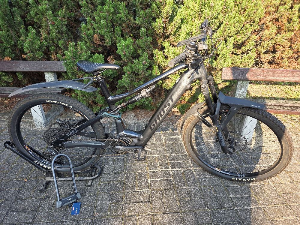 Rower elektryczny marki GHOST E-ASX 160 Universal wraz z podpórką na rower i zapięciem typu U-lock koloru czarnego