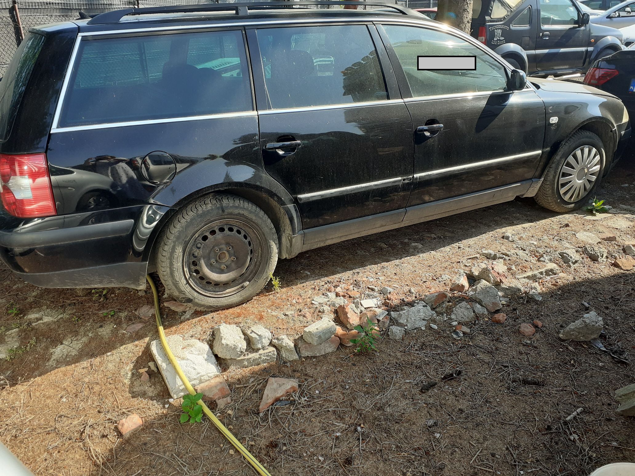 Czarny samochód osobowy marki Volkswagen Passat kombi widziany z prawej strony