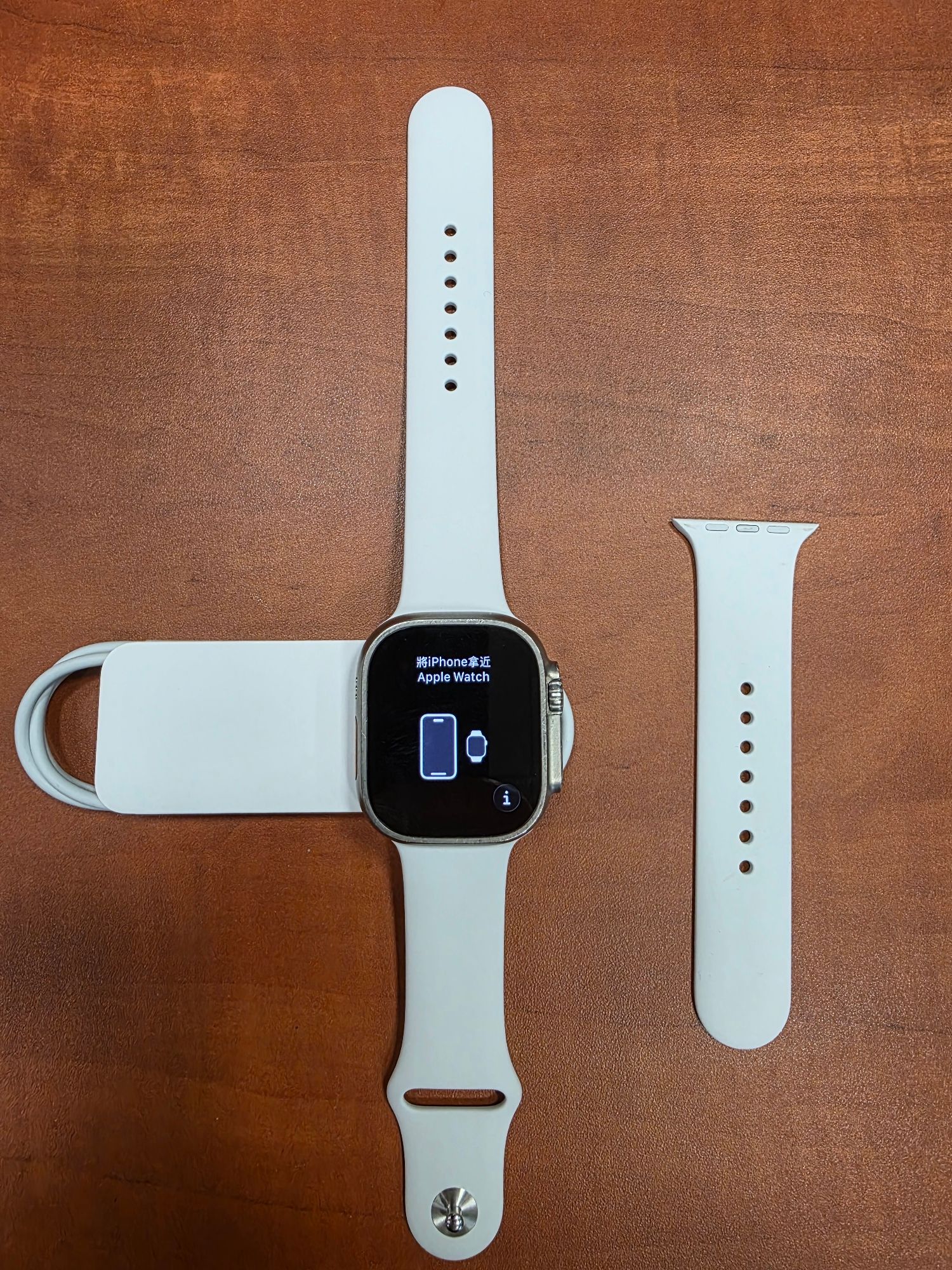 Apple Watch Ultra seria 1 koloru białego z częścią opaski koloru białego i kablem zasilającym koloru białego - strona przednia