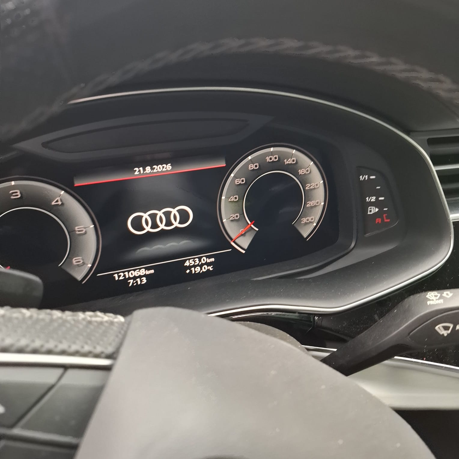 Cyfrowy wyświetlacz samochodu marki Audi pokazuje datę 21.8.2026, przebieg 121068 km.