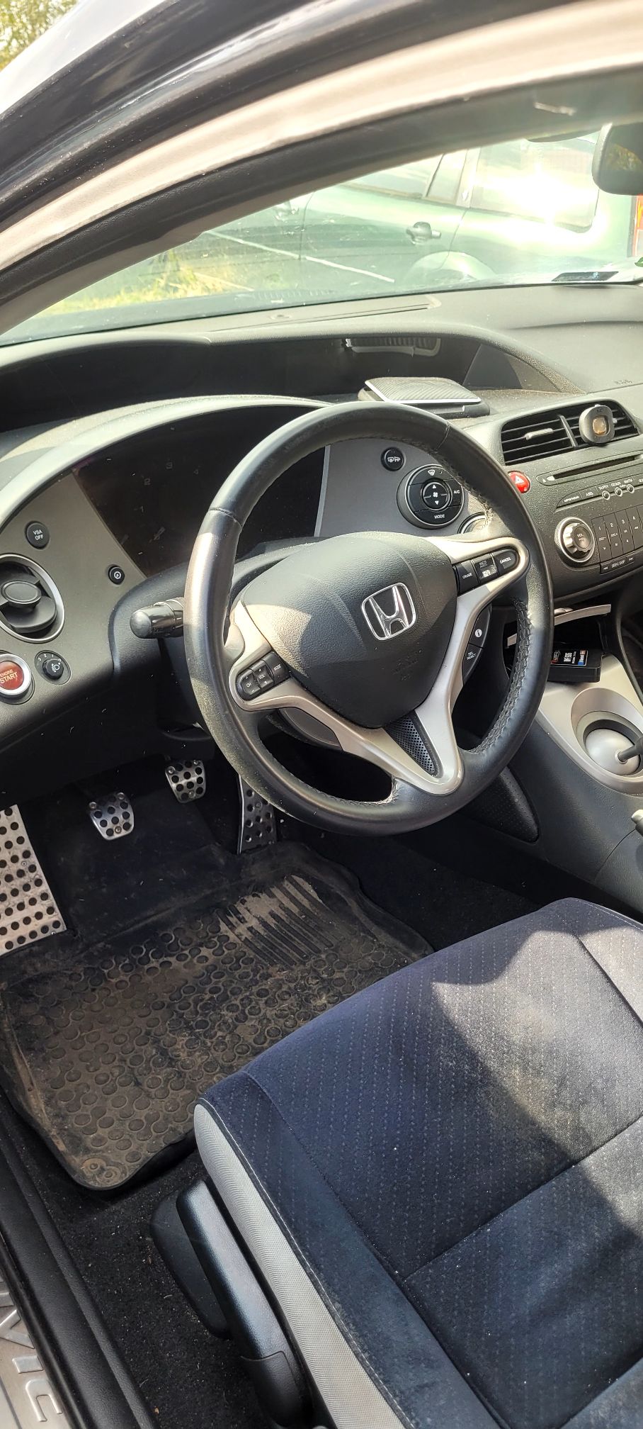 Zdjęcie przedstawia kierownicę oraz kokpit samochodu Honda Civic.