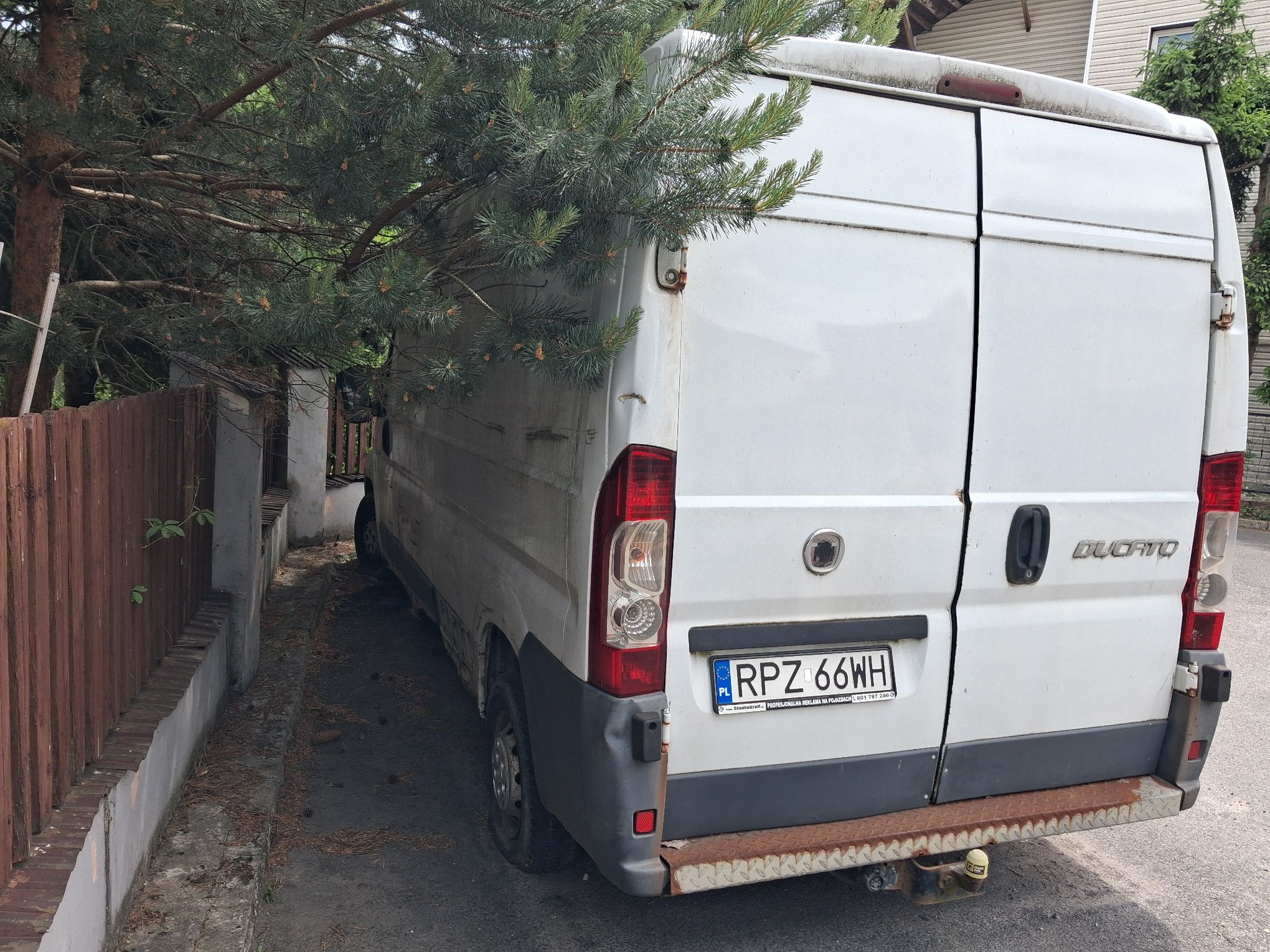 Tył białego samochodu typu furgon.