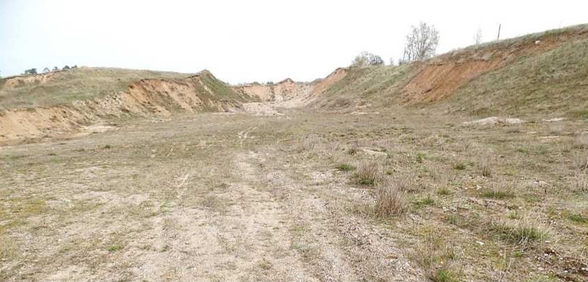 Szerokie wyrobisko żwirowni otoczone piaszczystymi zboczami